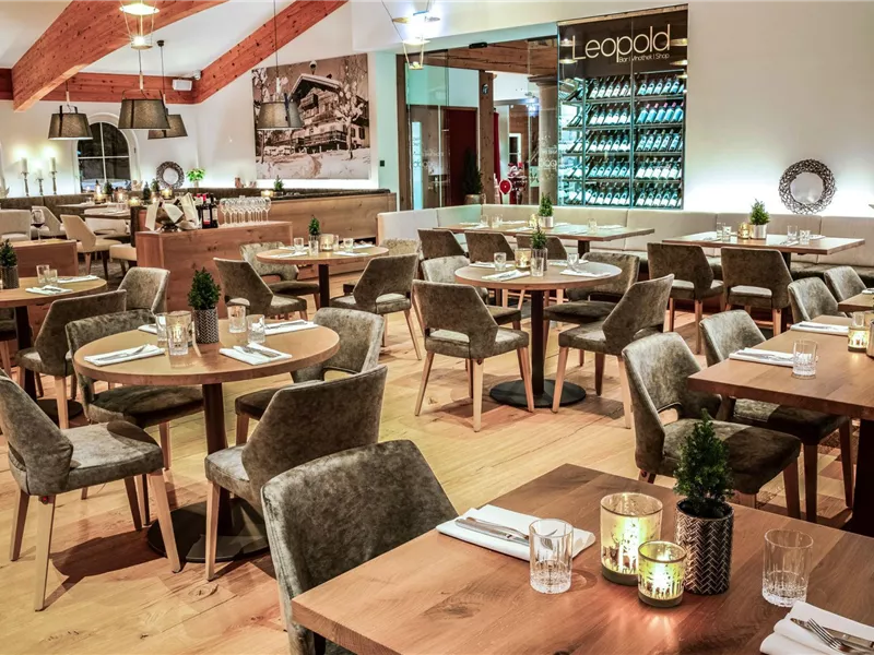 Ein modernes Restaurant mit Holzdekor und gemütlichen Tischen. Die Atmosphäre ist einladend und elegant.
