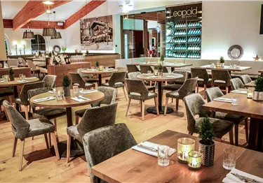 Ein modernes Restaurant mit Holzdekor und gemütlichen Tischen. Die Atmosphäre ist einladend und elegant.