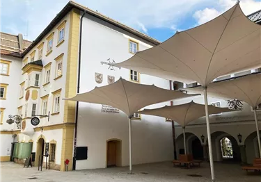 Eine große, mit weißen Planen bedeckte Fläche in einer felsigen Umgebung. Im Hintergrund ist ein klarer blauer Himmel zu sehen.