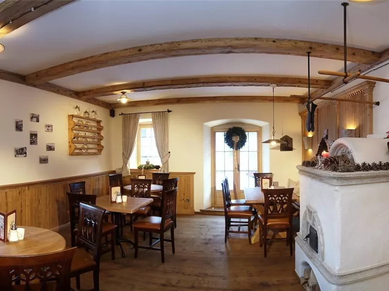 Ein gemütliches Restaurant mit Holzdecken und warmem Licht. Die Tische sind ordentlich gedeckt und laden zum Verweilen ein.