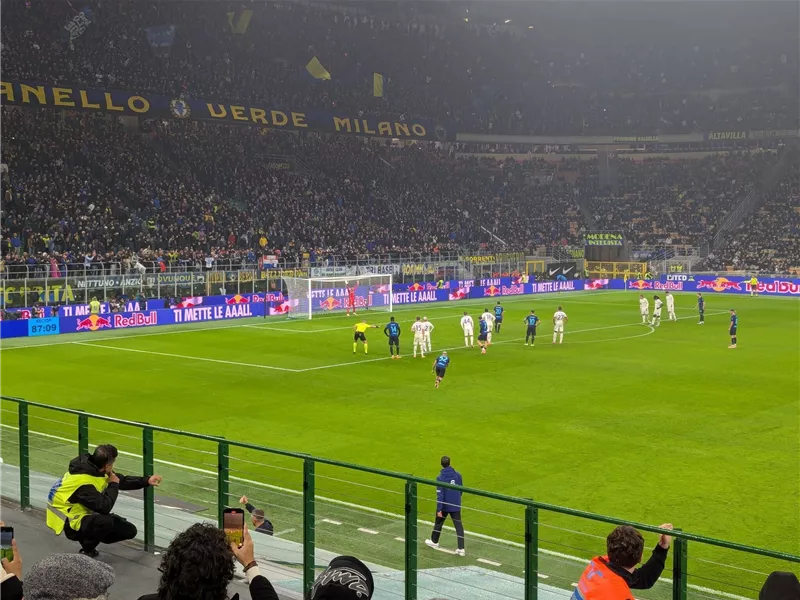 Ein Fußballspiel mit einer großen Menschenmenge im Stadion. Die Spieler sind bereit für einen Freistoß.