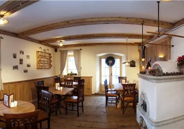 Ein gemütliches Restaurant mit Holzdecken und warmem Licht. Die Tische sind ordentlich gedeckt und laden zum Verweilen ein.