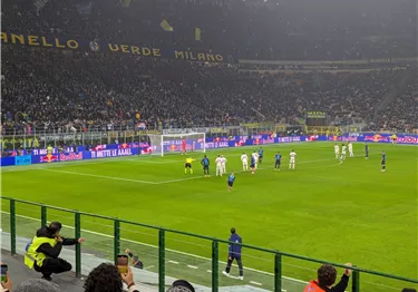 Ein Fußballspiel mit einer großen Menschenmenge im Stadion. Die Spieler sind bereit für einen Freistoß.