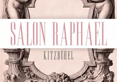 Ein elegantes Logo mit zwei Engeln und einem Löwenkopf. Darunter steht "Salon Raphael Kitzbühel" in stilvoller Schrift.